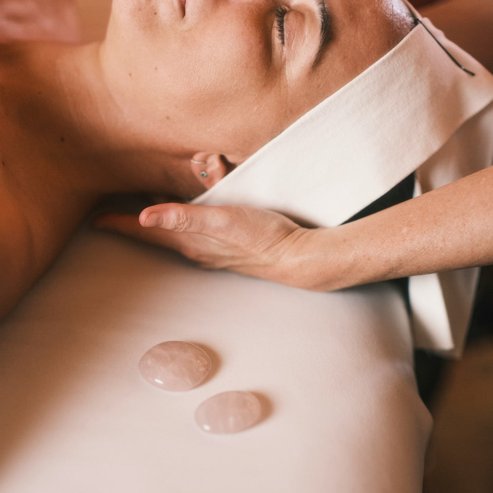 Person receiving a stone therapy massage on a blurred background