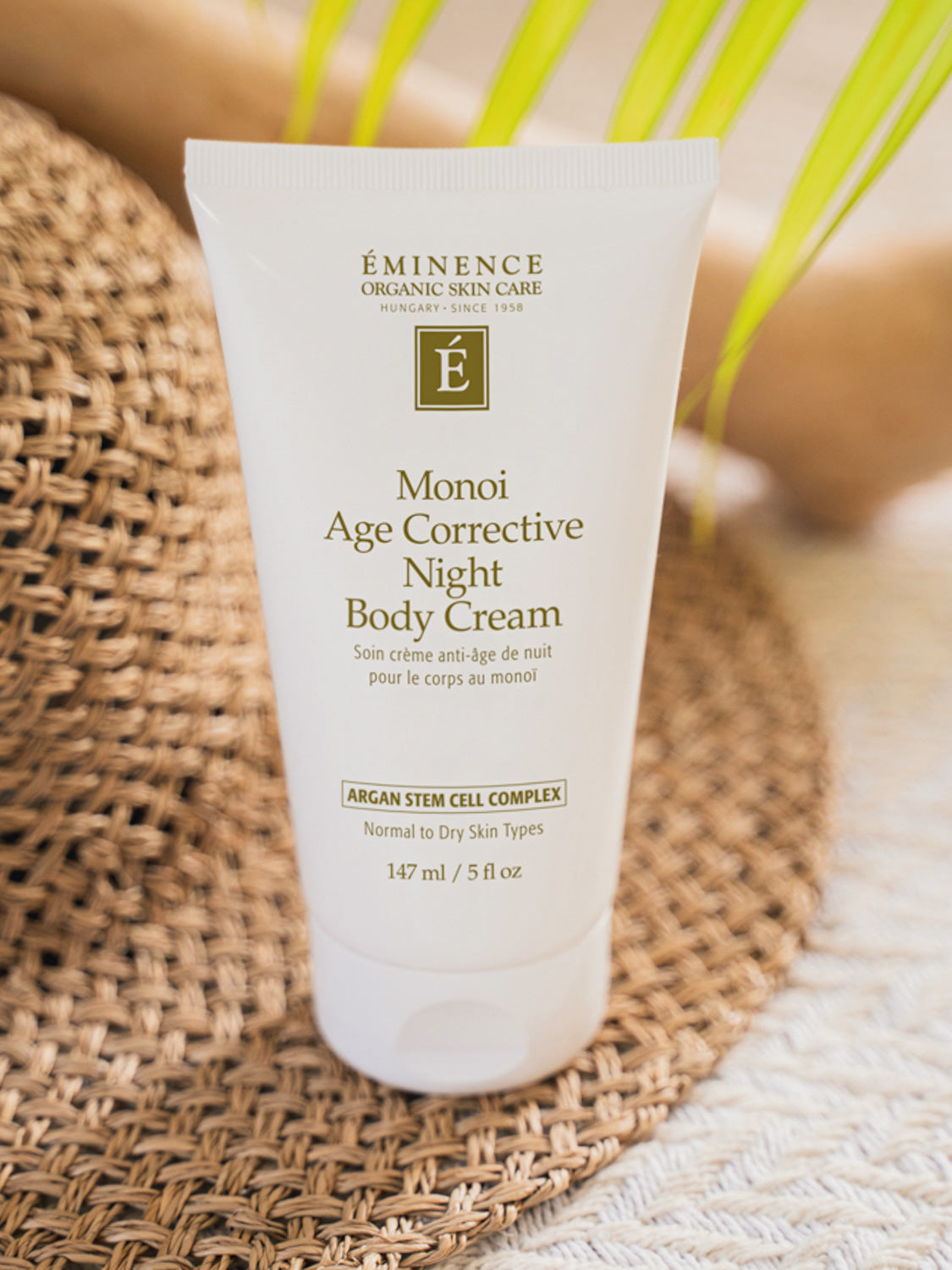 Eminence Monoi Age Corrective Night Body Cream on a woven mat