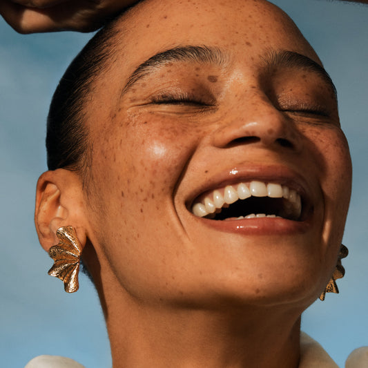 Woman smiling with hydrated, glowing skin after using Irene Forte Triple Level Hyaluronic Serum