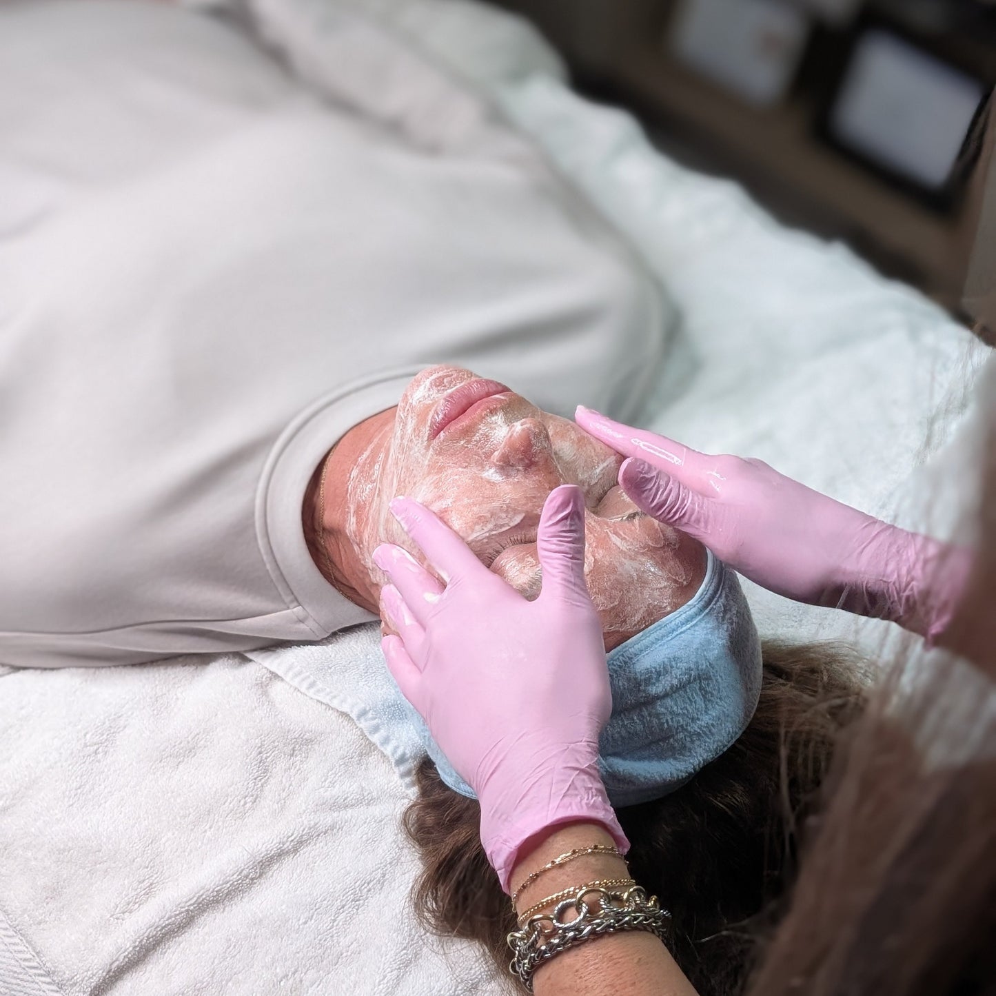 Person receiving a foot massage with gloves on a bed.