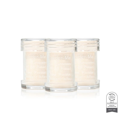 Three glass candles labeled 'Powder Me' on a white background with a certification badge.