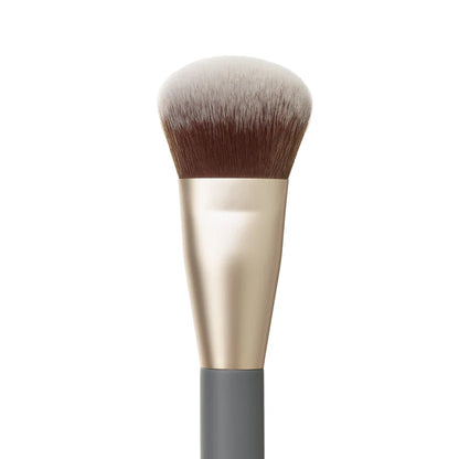 Makeup brush with gold and gray handle on a white background