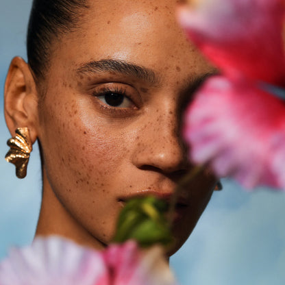Close-up of a person holding pink flowers with a blurred background
