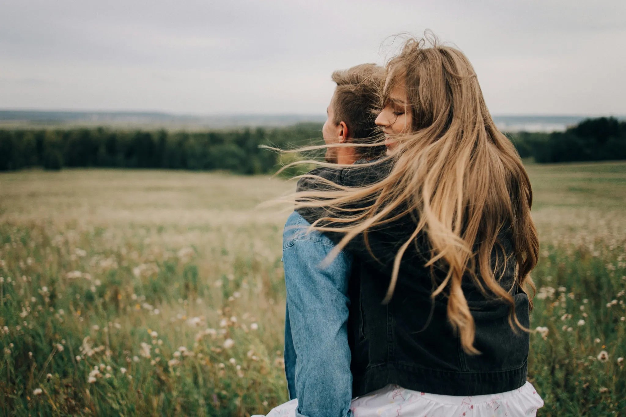 Couple embracing in a field with a blurred background