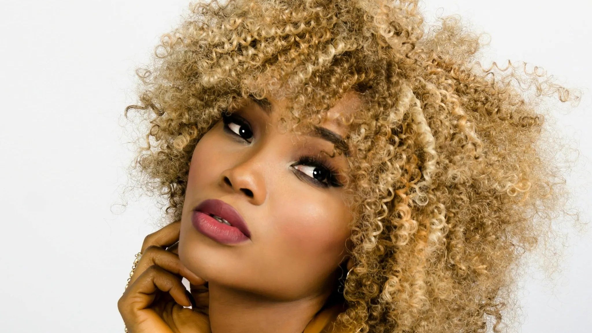 Woman with styled blonde hair against a white background