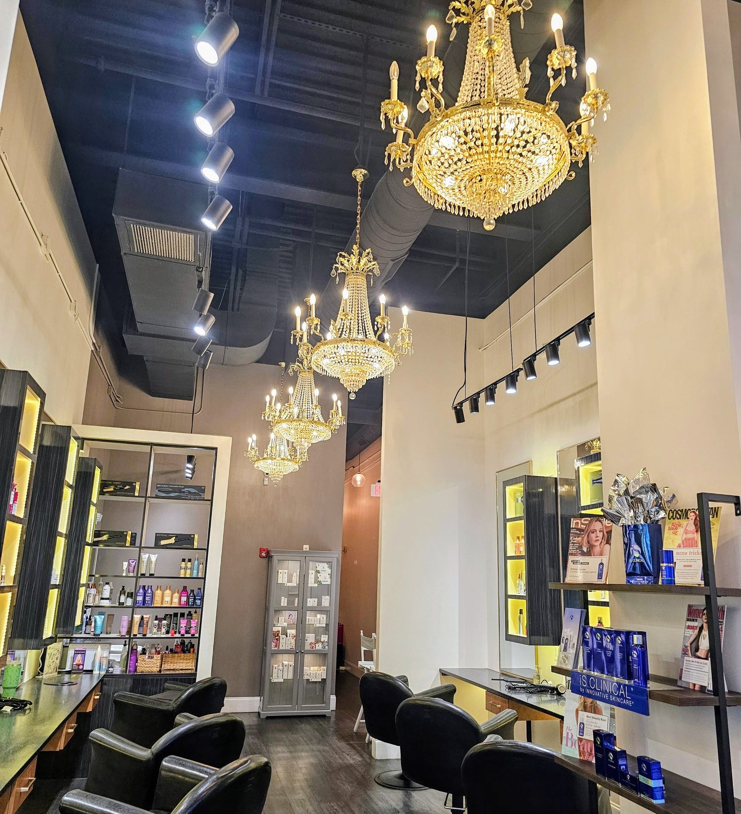 Salon interior with chandeliers, chairs, and product displays.
