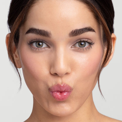 Model wearing Jane Iredale Just Kissed pH Lip Oil, lips pursed in a kiss.