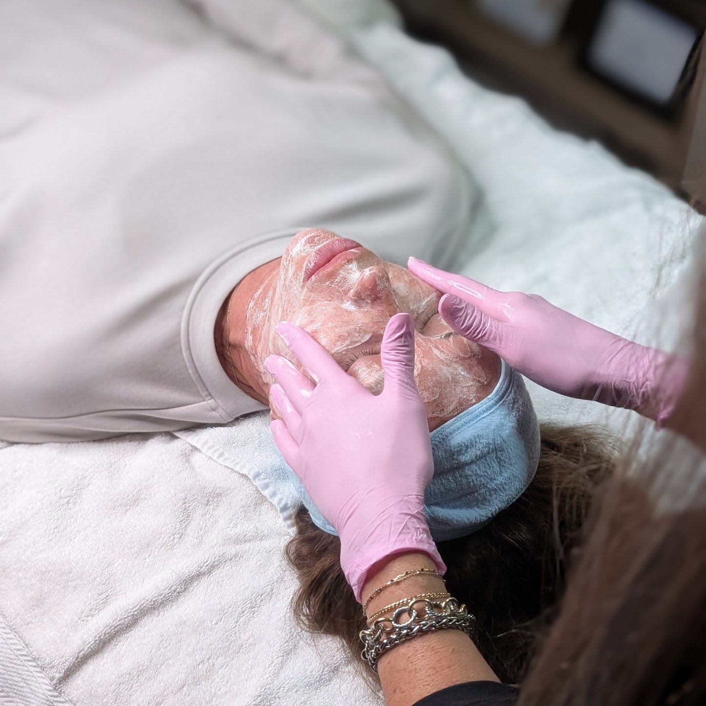 Close-up of a relaxing facial treatment with cleansing product application at Refined with Caroline