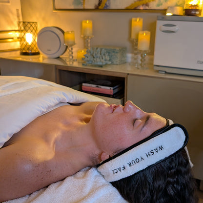 Person receiving a facial treatment with candles and decor in the background