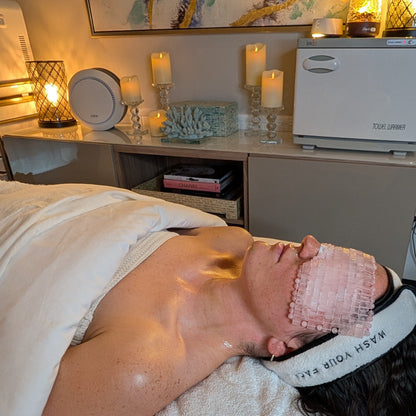 Person receiving a facial treatment with candles and decor in the background