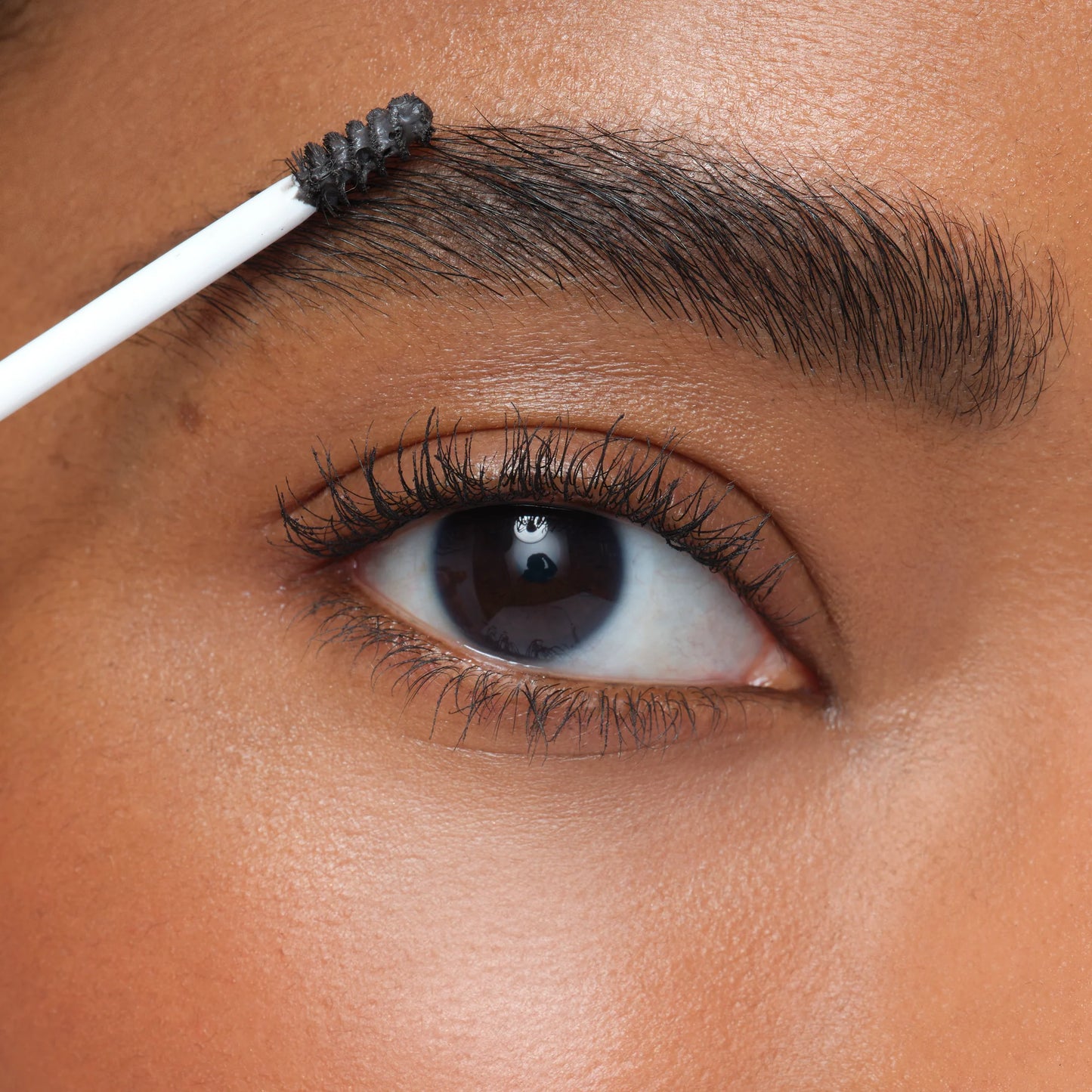 Close-up of a person applying eyebrow makeup with a brush.