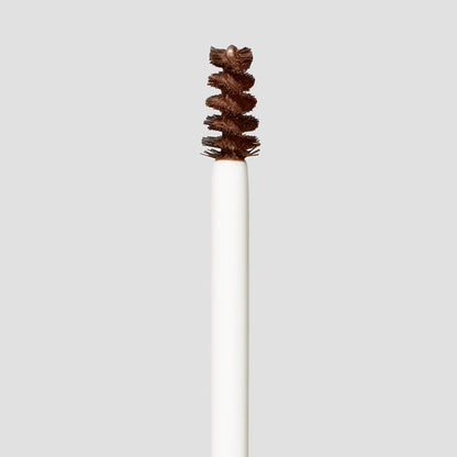 White makeup brush with brown bristles on a light gray background