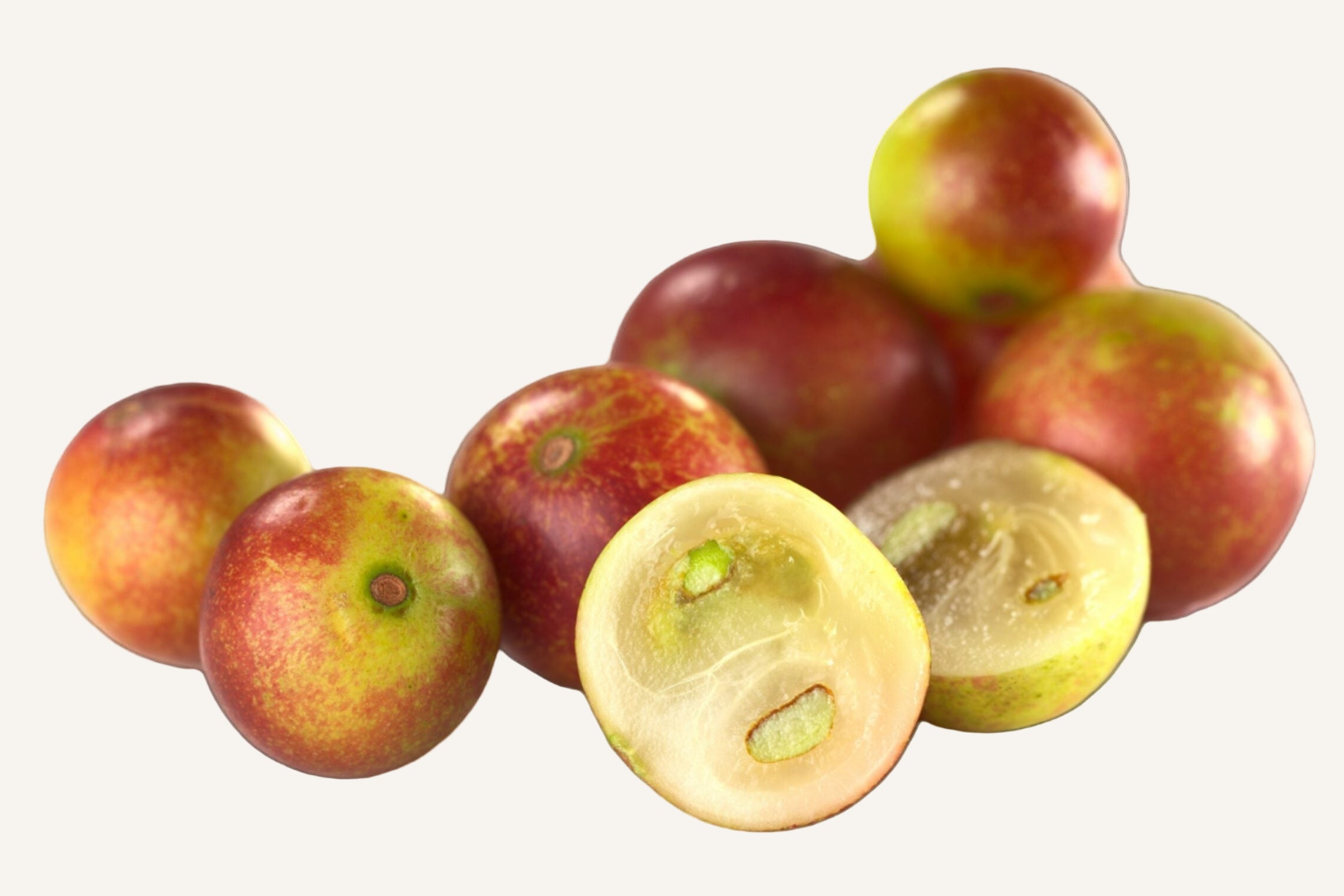 Group of red and green fruits with one cut open on a white background